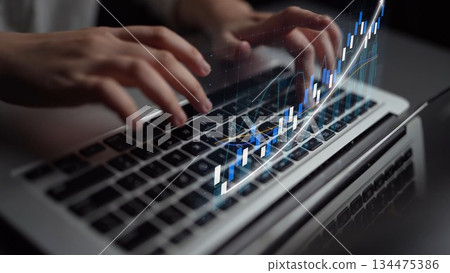 Person Typing on Laptop with Financial Graph Overlay Showing Growth and Progress in a Modern Office Environment Copula 134475386