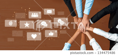 Collaborative Teamwork and Digital Connection in Modern Workplace with Hands Over Table and Creative Social Media Icons Trope Collaborative Teamwork and Digital Connection in Modern Workplace with Hands Over Table and Creative Social Media Icons Trope 134475486