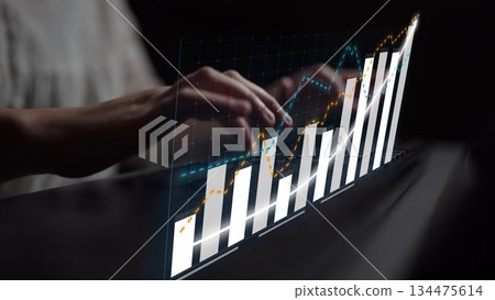 Modern Businesswoman Analyzing Financial Growth Data with Interactive Graphs and Charts on a Futuristic Digital Display in a Dark Office Setting Copula 134475614