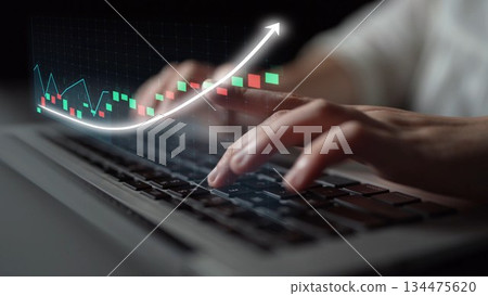 Human hands typing on a laptop keyboard with a glowing financial chart depicting growth and progress against a dark background, symbolizing data analysis Copula 134475620