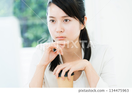 Woman drinking coffee while working Woman drinking coffee while working 134475963