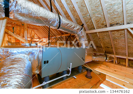 Installation of HVAC system in attic space during home construction process at residential building Installation of HVAC system in attic space during home construction process at residential building 134476162