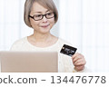 Senior woman enjoying online shopping on a computer 134476778