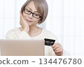 Senior woman enjoying online shopping on a computer 134476780