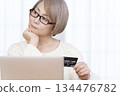 Senior woman enjoying online shopping on a computer 134476782