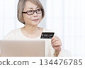 Senior woman enjoying online shopping on a computer 134476785