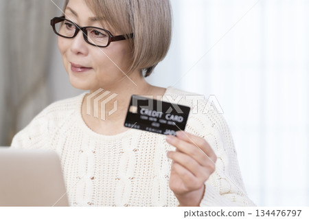 在電腦上享受網上購物的高級女性 134476797