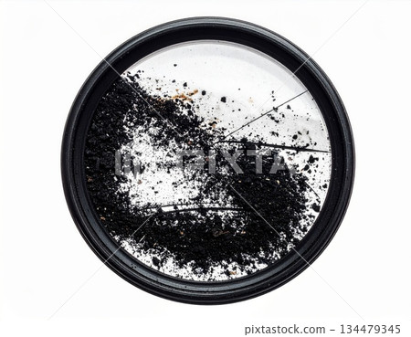Close up of camera lens filter filled with dark specks and debris on white background 134479345