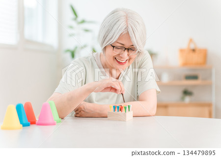Senior woman training in rehabilitation (stroke, hemiplegia, sequelae) Senior woman training in rehabilitation (stroke, hemiplegia, sequelae) 134479895