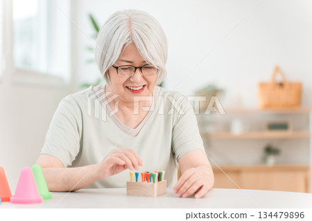 Senior woman training in rehabilitation (stroke, hemiplegia, sequelae) Senior woman training in rehabilitation (stroke, hemiplegia, sequelae) 134479896