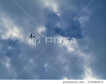 Silhouette of a light aircraft flying in a cloudy sky Silhouette of a light aircraft flying in a cloudy sky 134480042
