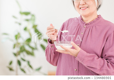 A gray-haired senior woman who eats yogurt and dairy products (bifidobacteria, lactic acid bacteria, dairy products, intestinal health) 134480301