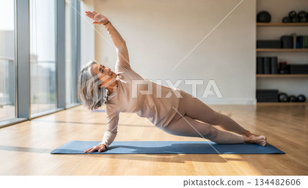 A beautiful elderly Japanese woman doing Pilates exercises in a gym. A practice of mindfulness and regular exercise for older adults 134482606