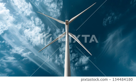 White wind turbines rotating against a blue sky 134484180