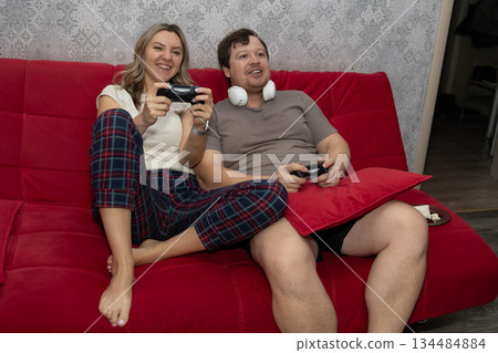 Partners Enjoy Cozy Game Night, Couple Relaxes Together During Casual Gaming Session 134484884