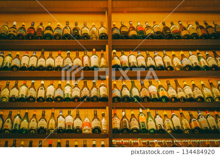 Wall of Wine Bottles: Assortment of Vintages on Illuminated Shelves 134484920