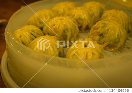 Warm Korean Pork Dumplings (Mandu) with Yellow Skin Steamed in a Bamboo Basket 134484956