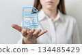 Woman presenting digital document with approval checkmark and stamp, showcasing modern technology and innovative business solutions in a professional setting 134485429