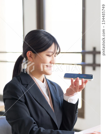 一位年輕的女企業家利用語音人工智慧來完成她的工作 一位年輕的女企業家利用語音人工智慧來完成她的工作 134485749