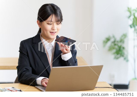 一名女員工在電腦上工作時使用語音人工智慧。 134485751