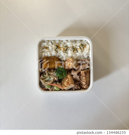 Bento or dosirak box filled with rice, assorted side dishes, vegetables, and protein like meat or fish, all neatly arranged to create a balanced, colorful, and visually appealing meal Bento or dosirak box filled with rice, assorted side dishes, vegetables, and protein like meat or fish, all neatly arranged to create a balanced, colorful, and visually appealing meal 134486235