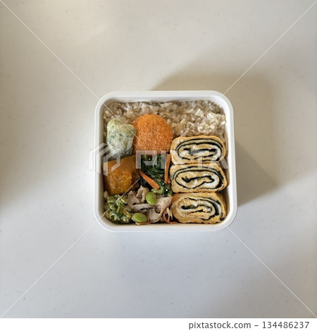 Bento or dosirak box filled with rice, assorted side dishes, vegetables, and protein like meat or fish, all neatly arranged to create a balanced, colorful, and visually appealing meal Bento or dosirak box filled with rice, assorted side dishes, vegetables, and protein like meat or fish, all neatly arranged to create a balanced, colorful, and visually appealing meal 134486237