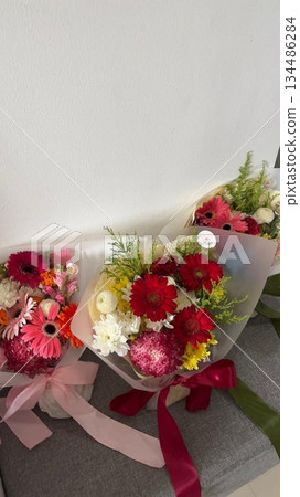 Bouquet of fresh flowers with vibrant colorful petals and lush green leaves, carefully arranged to highlight natural beauty, soft textures, and harmonious elegance in close-up detail Bouquet of fresh flowers with vibrant colorful petals and lush green leaves, carefully arranged to highlight natural beauty, soft textures, and harmonious elegance in close-up detail 134486284