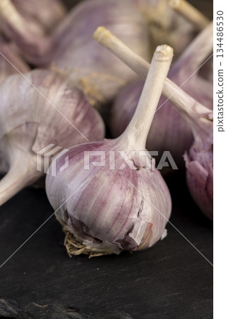 garlic spices are on a black slate board in the kitchen over cooking, close up garlic spices are on a black slate board in the kitchen over cooking, close up 134486530