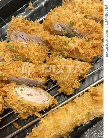 Crispy tonkatsu, a Japanese-style breaded and deep-fried pork cutlet, served with shredded cabbage and drizzled with savory sauce. A delightful balance of crunchy texture and juicy meat. Crispy tonkatsu, a Japanese-style breaded and deep-fried pork cutlet, served with shredded cabbage and drizzled with savory sauce. A delightful balance of crunchy texture and juicy meat. 134486564
