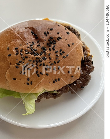 A mouthwatering burger with a juicy patty, fresh lettuce, tomato, and melted cheese, all nestled in a soft bun. Perfect for food photography, showcasing the indulgence of classic comfort food. A mouthwatering burger with a juicy patty, fresh lettuce, tomato, and melted cheese, all nestled in a soft bun. Perfect for food photography, showcasing the indulgence of classic comfort food. 134486660