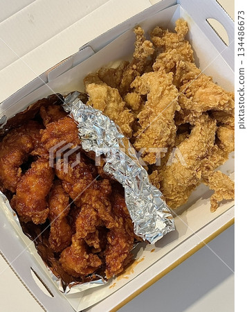 Crispy Korean fried chicken, perfectly glazed with a sweet and spicy sauce. Ideal for food photography and menus, showcasing the irresistible crunch and flavor of this beloved dish. 134486673