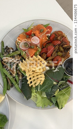 A delightful brunch spread featuring a mix of savory and sweet dishes, including fresh pastries, eggs, seasonal fruits, and a hot beverage. A perfect mid-morning indulgence. 134486675