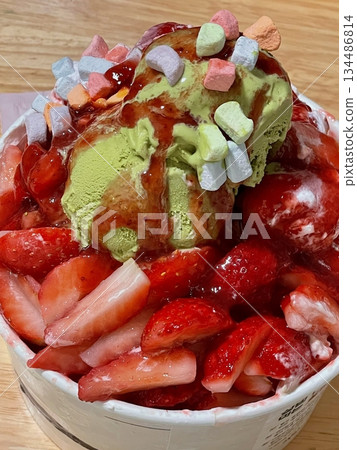 Refreshing bingsu, a Korean shaved ice dessert topped with sweet ingredients like red beans, fruits, and condensed milk. A perfect treat to cool down on hot days. Refreshing bingsu, a Korean shaved ice dessert topped with sweet ingredients like red beans, fruits, and condensed milk. A perfect treat to cool down on hot days. 134486814