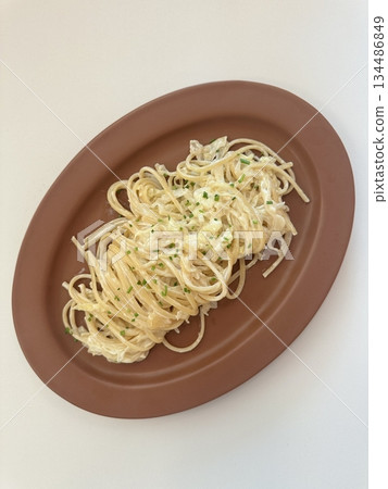A plate of spaghetti pasta, perfectly cooked and topped with rich marinara sauce and fresh herbs. Ideal for food photography and menus, capturing the heart of Italian cuisine in a delicious way. 134486849