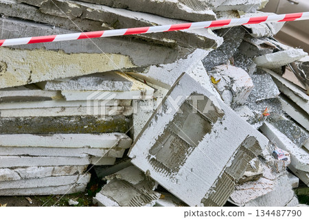 Waste old insulation material removed from walls.Fenced red tape Waste old insulation material removed from walls.Fenced red tape 134487790