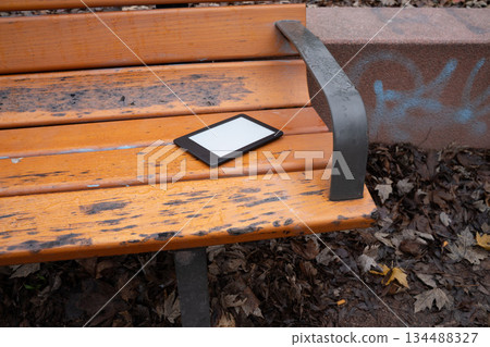 Ebook on a light wooden park bench Ebook on a light wooden park bench 134488327