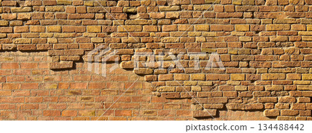 Old weathered brick wall showing crumbling texture background 134488442
