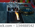 Modern dining table with fire feature and elegant tableware setup 134488542