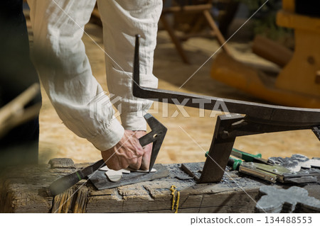 Berlin, Germany - January 22, 2024: Craftsman using tools on wooden workbench in workshop 134488553