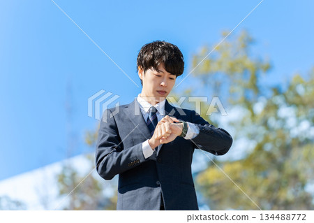 Businessman, blue sky, clock Businessman, blue sky, clock 134488772