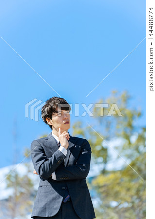 Businessman thinking under blue sky Businessman thinking under blue sky 134488773