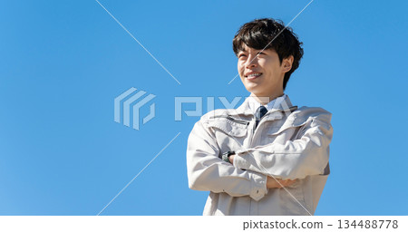 Young man in work clothes, blue sky 134488778