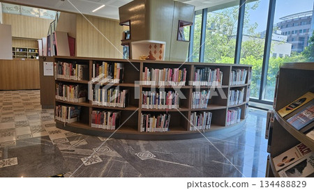 A polished library interior with marble floors and sunlit windows showcases curated cookbooks and lifestyle titles, inviting readers into a calm, organized space for learning and discovery 134488829