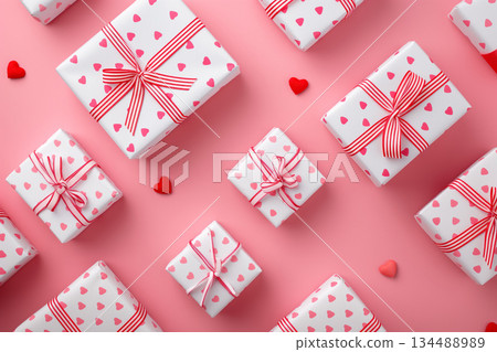 Aerial view of heart-patterned gift boxes lined up against a pink background 134488989