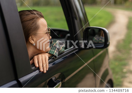 Woman travel car window view enjoying summer road trip adventure vacation concept 134489716