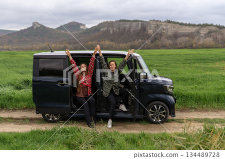 Travel women car enjoying freedom on a road trip sitting in an open van Travel women car enjoying freedom on a road trip sitting in an open van 134489728
