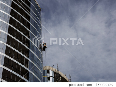 Construction worker on a suspended cradle 134490429