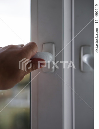 man opening window in flat. man opening window in flat. 134490449