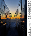 Sunset seen from between the large buses 134490520