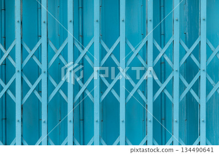 Blue expandable steel gate showing a traditional folding mechanism Blue expandable steel gate showing a traditional folding mechanism 134490641